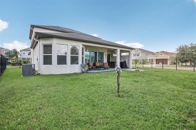 rear view of property with stucco siding, a lawn, a patio, central AC, and a fenced backyard