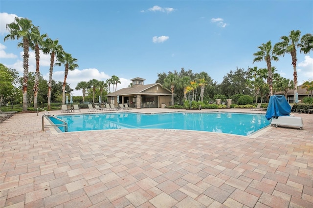 community pool with a patio area and fence