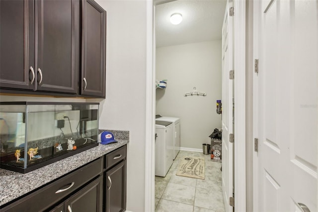 laundry room with light tile patterned floors, baseboards, laundry area, and washer and clothes dryer