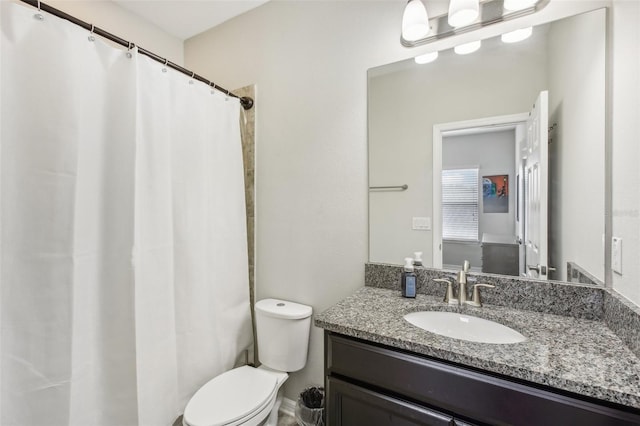 bathroom featuring curtained shower, vanity, and toilet