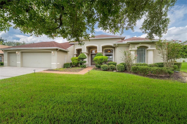 mediterranean / spanish-style home featuring driveway, stucco siding, an attached garage, and a front lawn