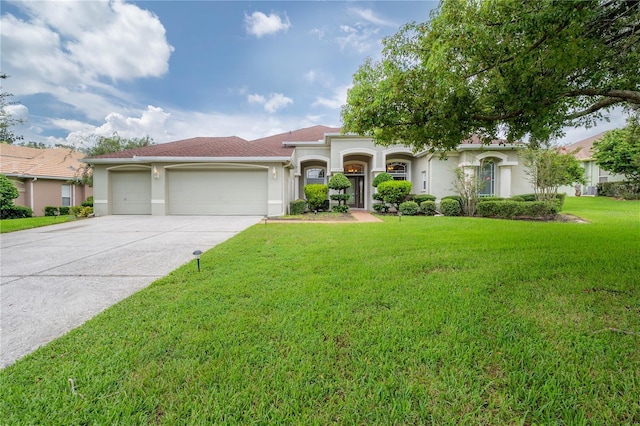mediterranean / spanish-style home with a front lawn, concrete driveway, stucco siding, and an attached garage