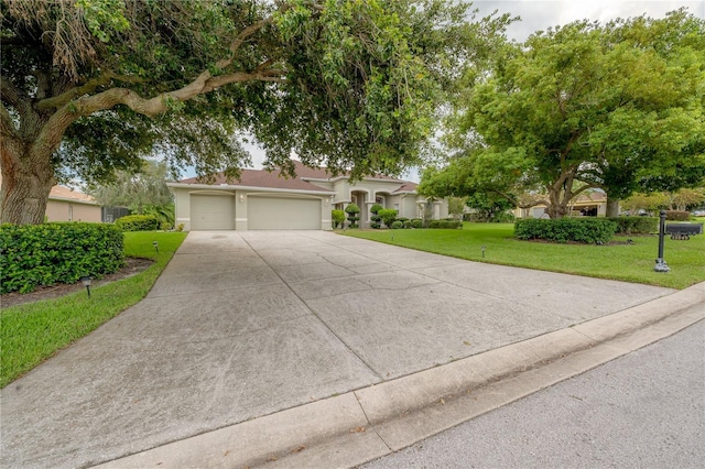 view of front facade with driveway, an attached garage, a front lawn, and stucco siding