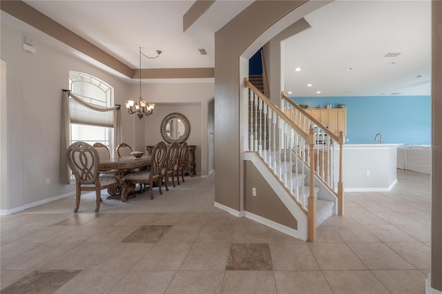 dining area with light tile patterned flooring, stairs, baseboards, and a notable chandelier