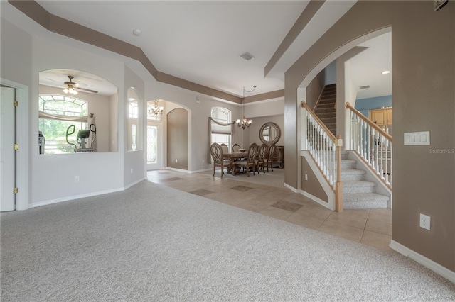 unfurnished living room with light colored carpet and ceiling fan with notable chandelier