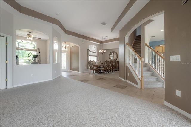 entryway featuring stairs, baseboards, tile patterned floors, carpet floors, and arched walkways