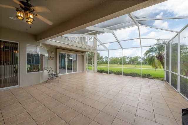 unfurnished sunroom with beam ceiling and ceiling fan