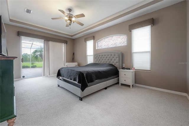 bedroom featuring a tray ceiling, ceiling fan, access to exterior, and light carpet