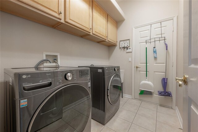 laundry room with baseboards, separate washer and dryer, cabinet space, and light tile patterned floors