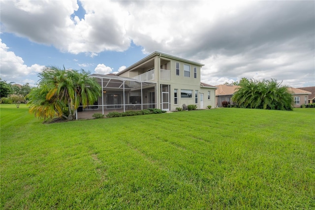 back of property with glass enclosure and a yard