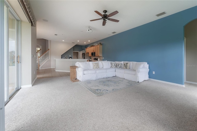 unfurnished living room with vaulted ceiling, ceiling fan, and light colored carpet