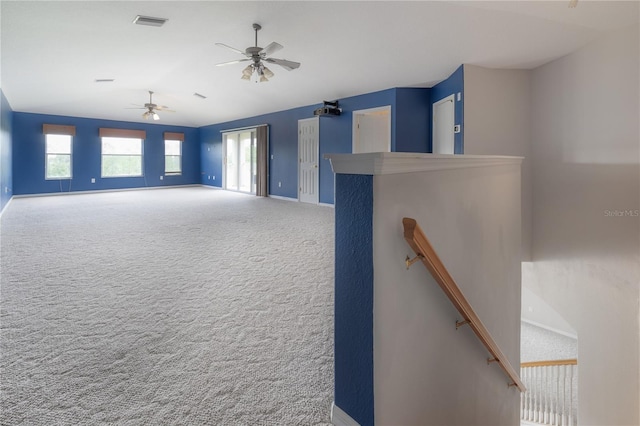 empty room featuring vaulted ceiling, baseboards, visible vents, ceiling fan, and carpet