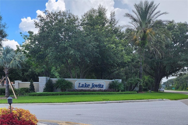 community / neighborhood sign featuring a lawn