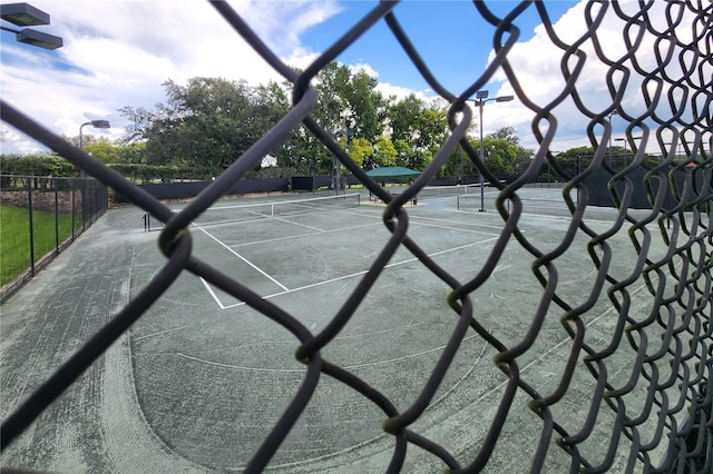 view of tennis court featuring fence