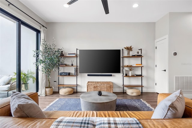 living area with recessed lighting, visible vents, ceiling fan, and wood finished floors