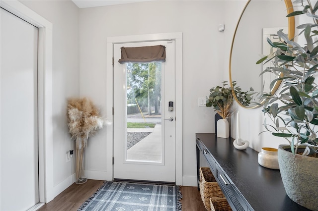 entryway with dark wood-type flooring and baseboards