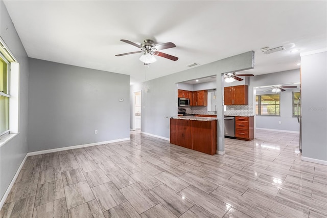 kitchen featuring ceiling fan, tasteful backsplash, kitchen peninsula, and appliances with stainless steel finishes