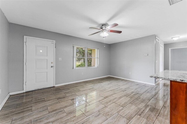 unfurnished living room with ceiling fan