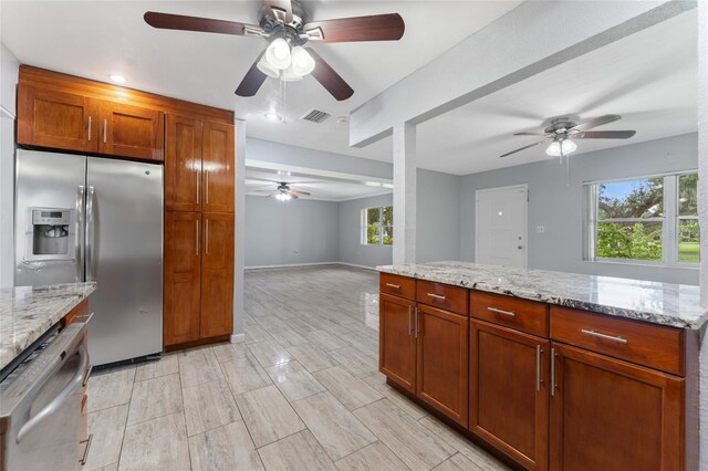 kitchen with ceiling fan, light stone countertops, and stainless steel appliances