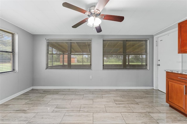 tiled spare room featuring ceiling fan