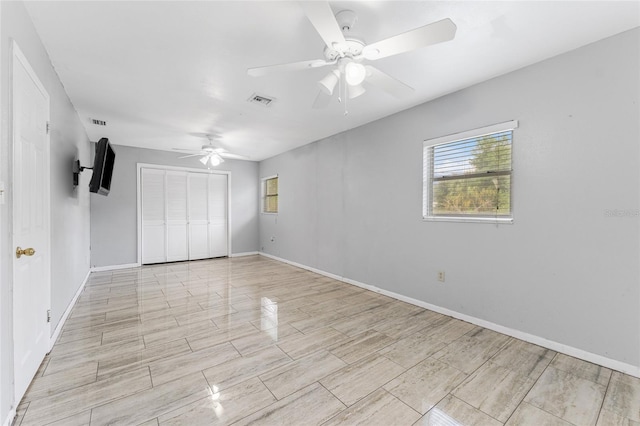 unfurnished bedroom with ceiling fan and a closet