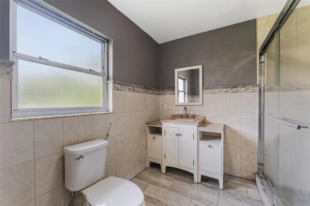 bathroom featuring tile walls, tile patterned floors, and a healthy amount of sunlight