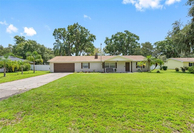 single story home with a garage and a front lawn