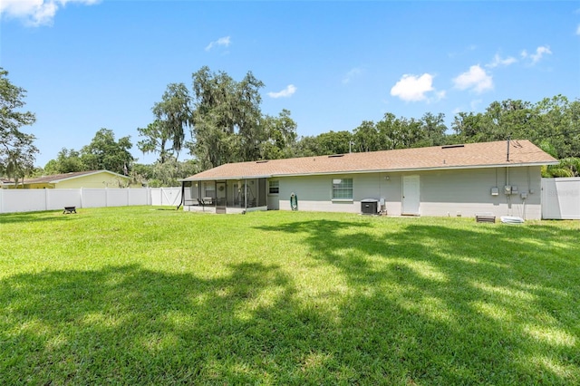 back of house with a lawn, a sunroom, and cooling unit