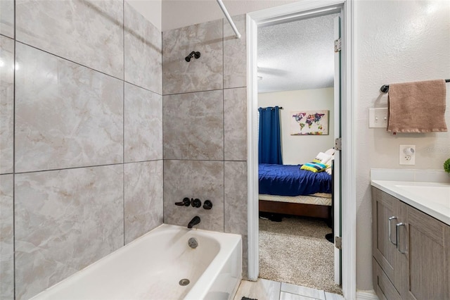 bathroom with tiled shower / bath combo, tile patterned flooring, a textured ceiling, and vanity