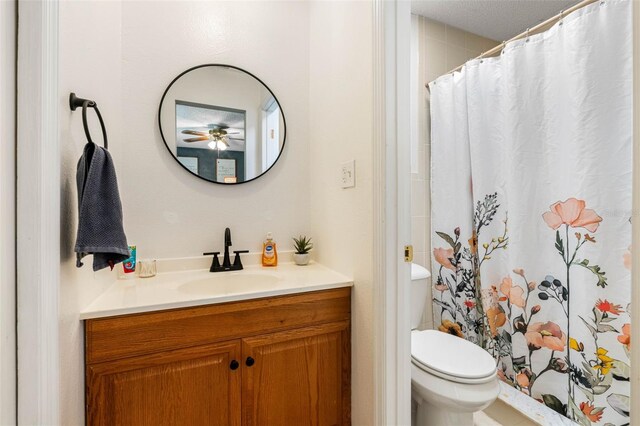 bathroom featuring a textured ceiling, toilet, and vanity