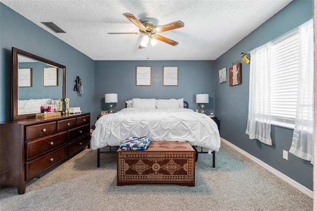 carpeted bedroom featuring a textured ceiling and ceiling fan