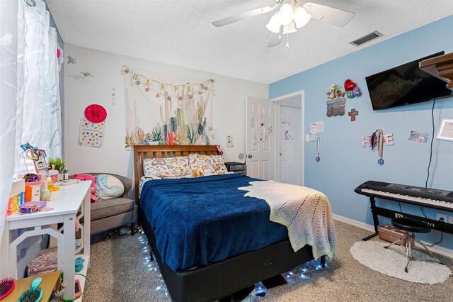 carpeted bedroom featuring a textured ceiling and ceiling fan