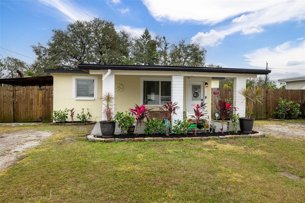 view of front of home with a front lawn and a carport