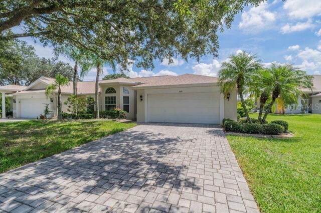 single story home featuring a garage and a front yard