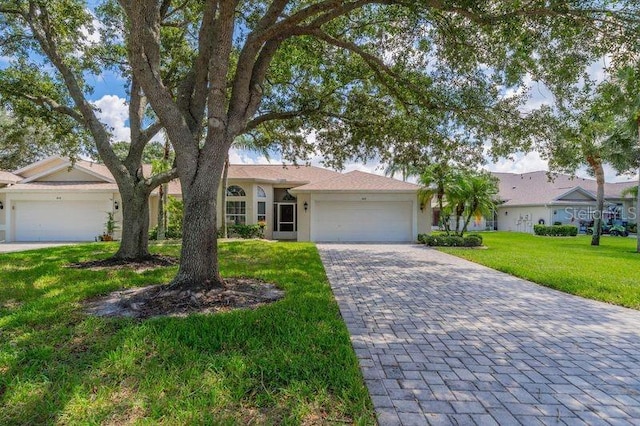 ranch-style home featuring a garage and a front lawn