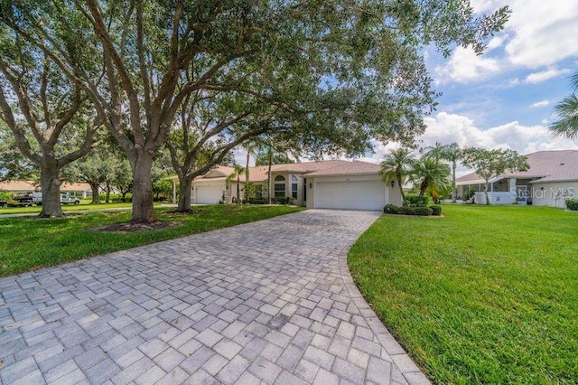 ranch-style house featuring a garage and a front lawn