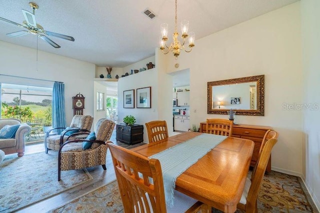 dining space with ceiling fan with notable chandelier and wood-type flooring