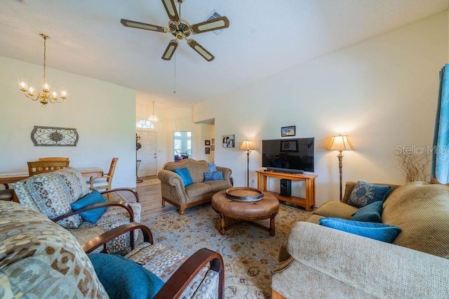 living room featuring ceiling fan with notable chandelier and hardwood / wood-style floors