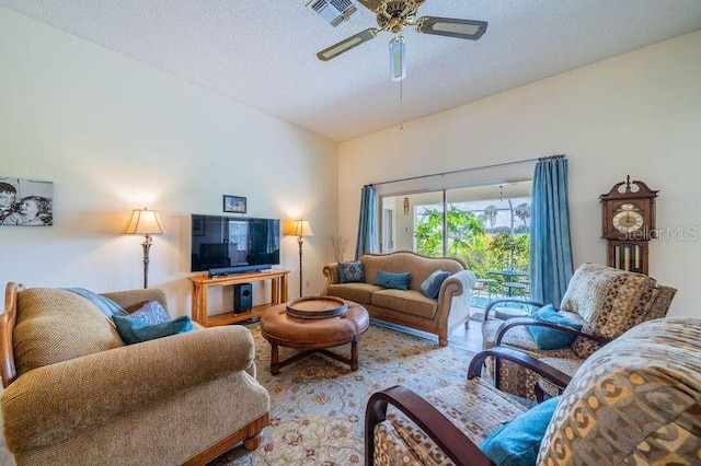 living room with a textured ceiling, ceiling fan, and lofted ceiling