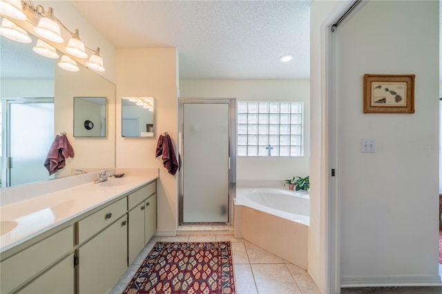 bathroom with vanity, a textured ceiling, plus walk in shower, and tile patterned floors