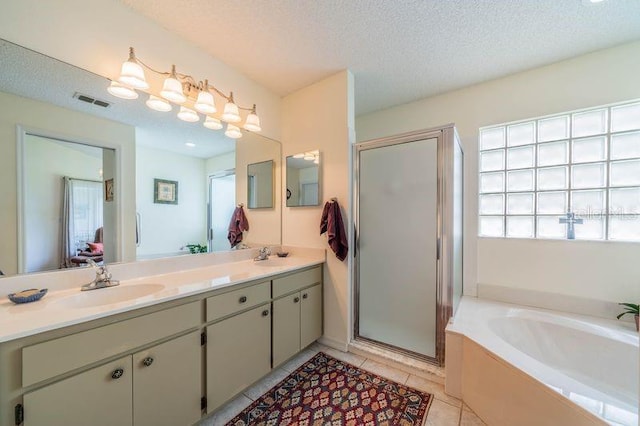 bathroom featuring vanity, a textured ceiling, plus walk in shower, and tile patterned flooring