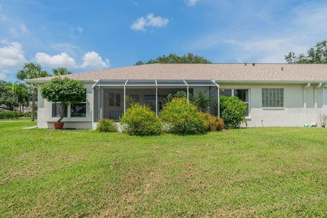 rear view of property with a yard and a lanai