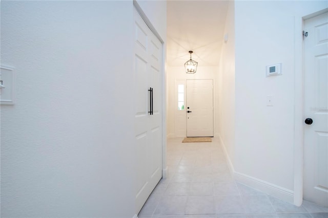 hallway with baseboards and light tile patterned floors