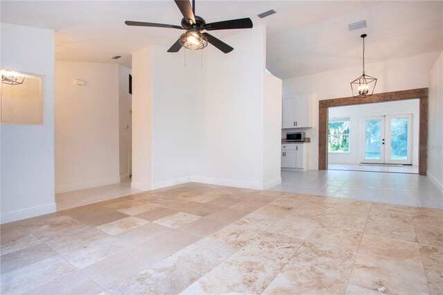 unfurnished room featuring french doors, visible vents, baseboards, and ceiling fan with notable chandelier