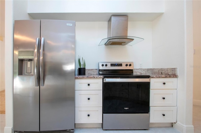 kitchen with white cabinetry, appliances with stainless steel finishes, light tile patterned floors, and wall chimney range hood