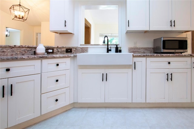 kitchen with decorative light fixtures, light tile patterned flooring, and white cabinetry