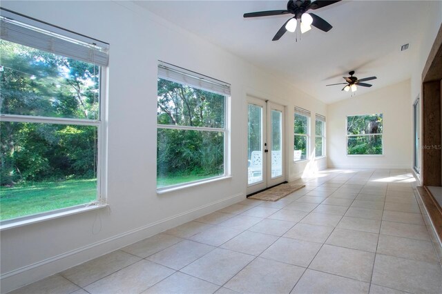 unfurnished sunroom featuring vaulted ceiling, visible vents, and a ceiling fan