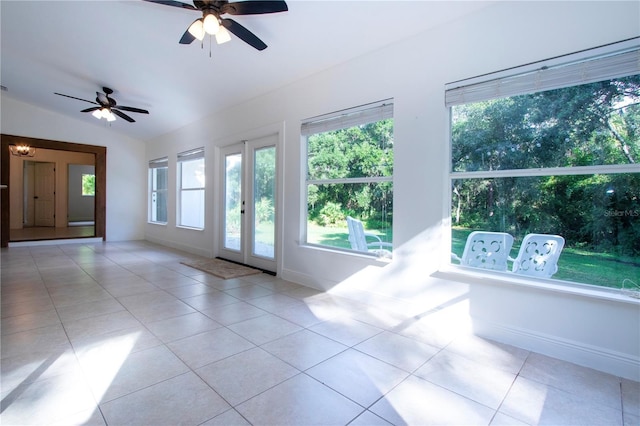 unfurnished living room with ceiling fan, baseboards, vaulted ceiling, and light tile patterned flooring