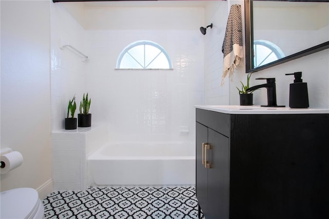 full bathroom featuring toilet, tiled shower / bath combo, vanity, and tile patterned floors