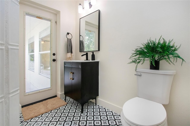 bathroom featuring tile patterned floors, vanity, a healthy amount of sunlight, and toilet